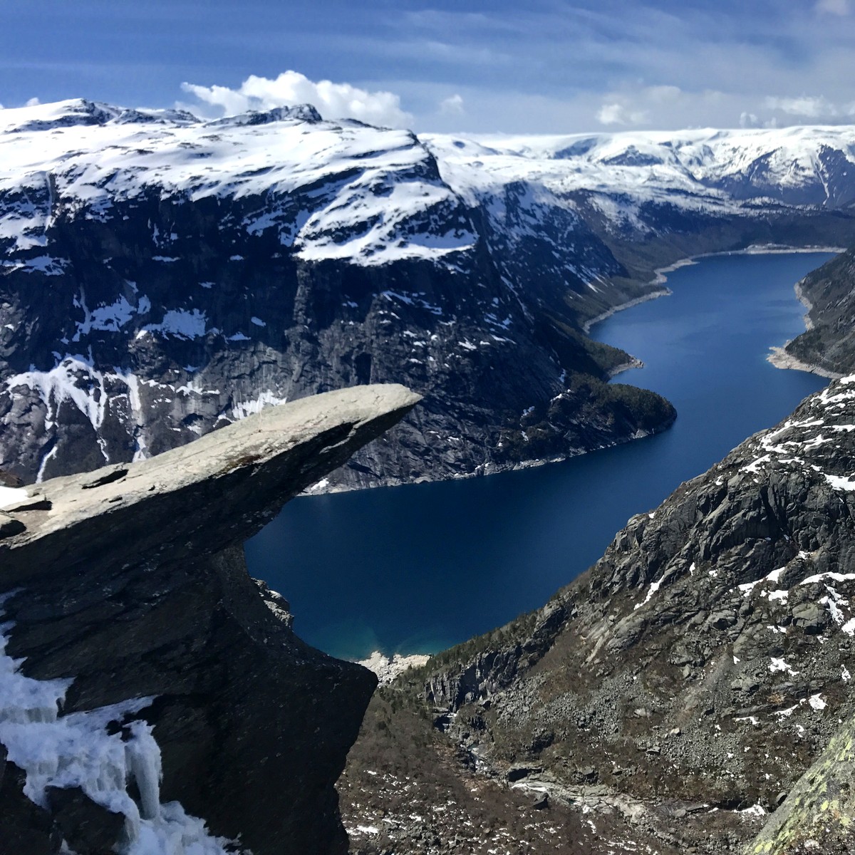 Trolltunga from the approach on 15 May 2017, snow on the ground and the tongue empty above Ringedalsvatnet